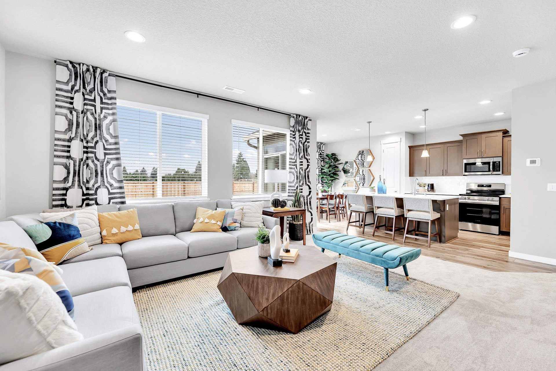 Living room with geometric curtain and coffee table with pops of color in pillows and bench